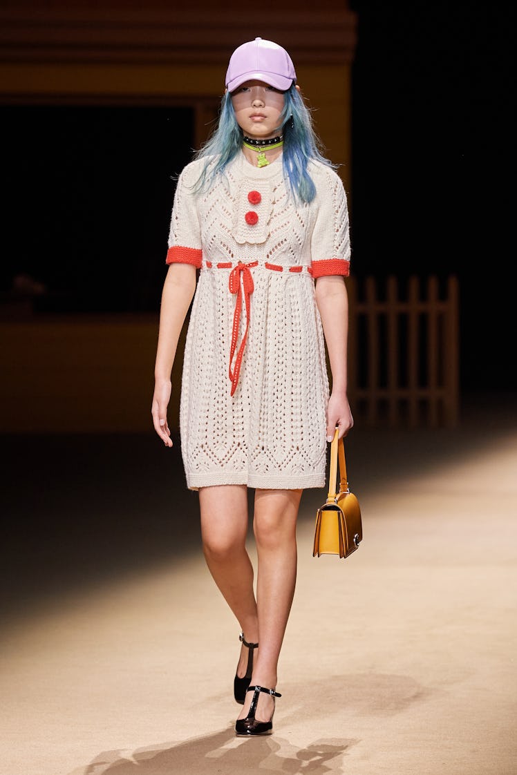 Model on the NY Fashion Week Fall 2022 runway in a Coach white knitted dress with red details