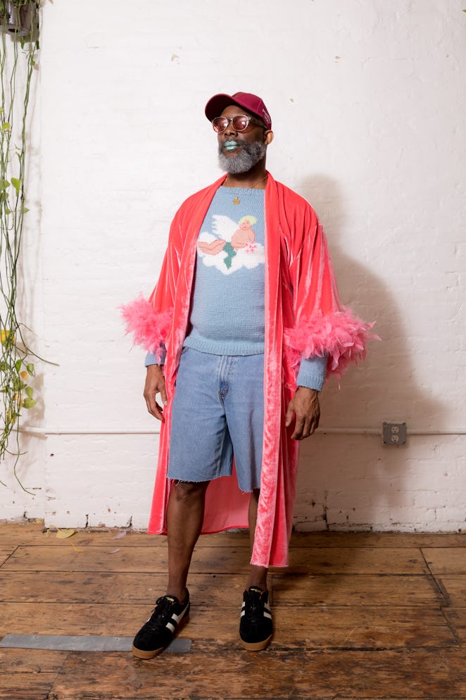 A model wearing grey clothes and a pink cape from Dauphinette's Fall 2022 collection.