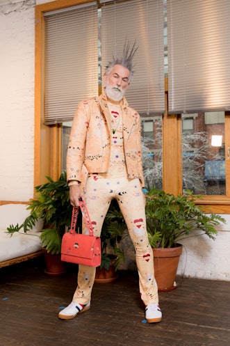A model wearing white and beige clothes and a red bag from Dauphinette's Fall 2022 collection.