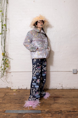 A model wearing a puffy silver jacket and wide denim pants with colorful floral details from Dauphin...