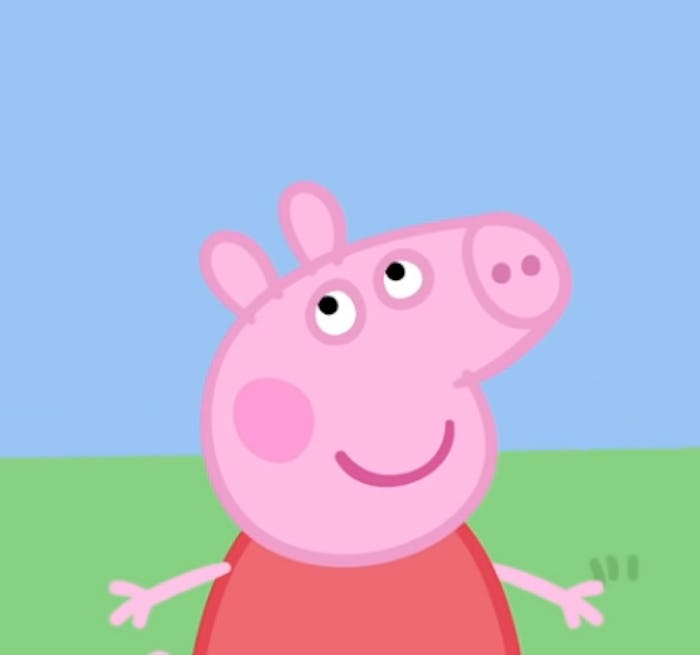 Peppa Pig looks upward against a blue sky.