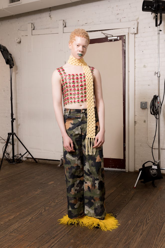 A model wearing a white and red squared shirt and camo pants from Dauphinette's Fall 2022 collection...
