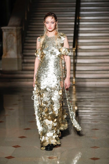 Gigi Hadid on the NY Fashion Week Fall 2022 runway in an Altuzarra gold and silver sequined dress