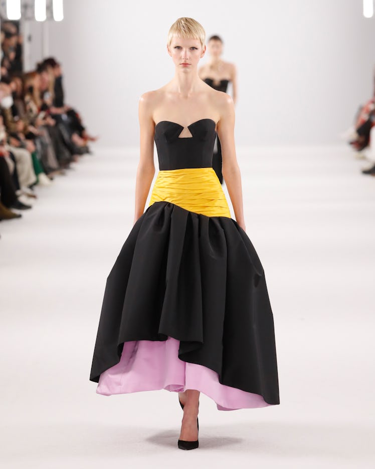 Model on the NY Fashion Week Fall 2022 runway in a Carolina Herrera black dress with yellow details