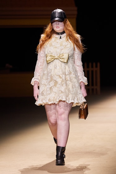 Model on the NY Fashion Week Fall 2022 runway in a Coach white dress with a golden bowtie