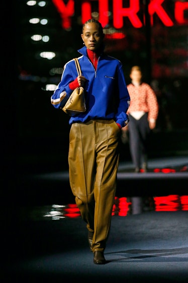 Model on the NY Fashion Week Fall 2022 runway in a Tory Burch blue sporty jacket and brown leather p...