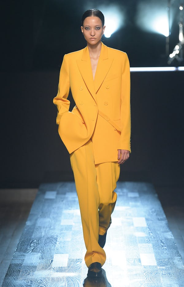 a model wearing a marigold suit on the Michael Kors Collection runway
