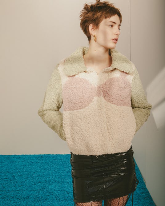 Model for designer Colin LoCascio wearing a black leather skirt and a big beige and pink sweater