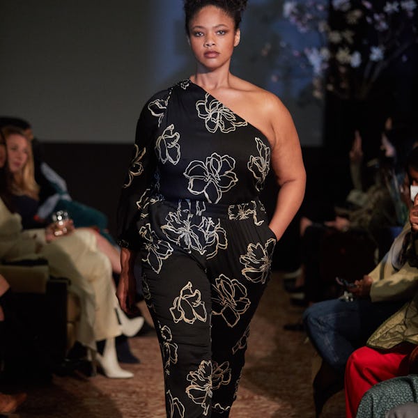 A model wearing a black floral print top and pants on the 11 Honoré runway