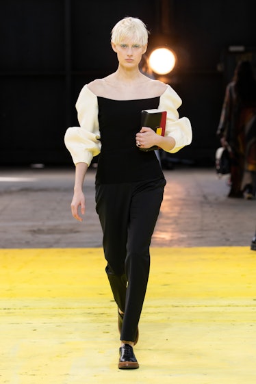 Model on the NY Fashion Week Fall 2022 runway in a Gabriela Hearst black top with white sleeves and ...