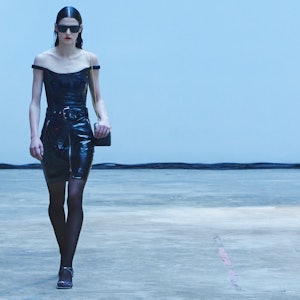 A model in a black leather off-the-shoulder dress on the Kite runway