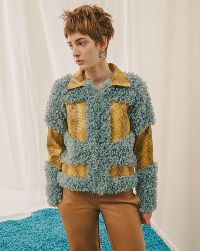 Model for designer Colin LoCascio wearing a yellow leather snake print jacket covered with blue puff...