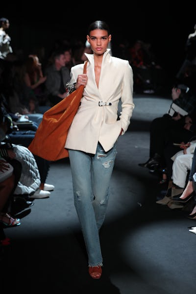 a model wearing a white blazer and jeans on the Brandon Maxwell runway