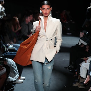 A model in a white blazer and jeans on the Brandon Maxwell runway