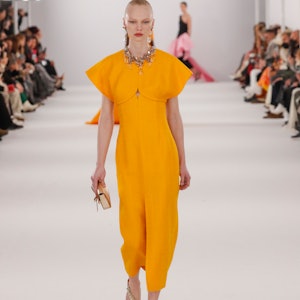 a model wearing a marigold dress on the Carolina Herrera runway