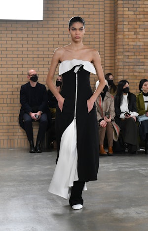 a model wearing a black and white strapless dress over black pants on the Proenza Schouler runway
