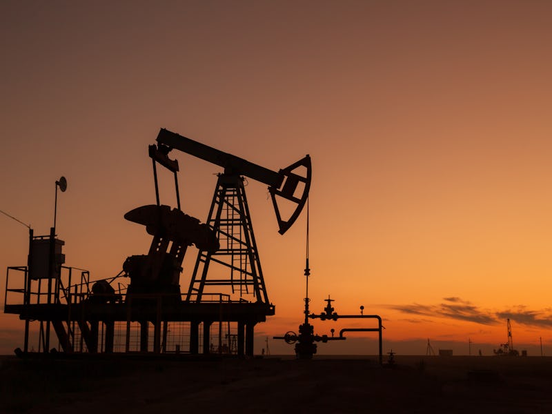Oil pump extracting fossil fuels at sunset