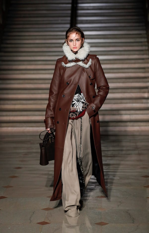 a model wearing a brown leather duster coat on the Altuzarra runway