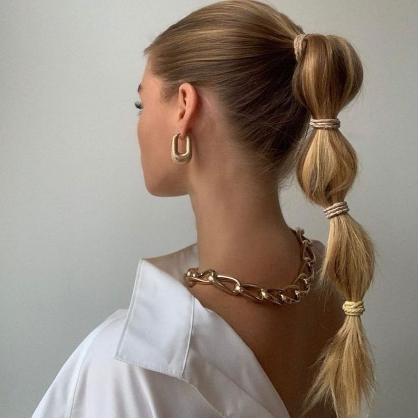 A woman wears clip-in extensions styled into a bubble pony.