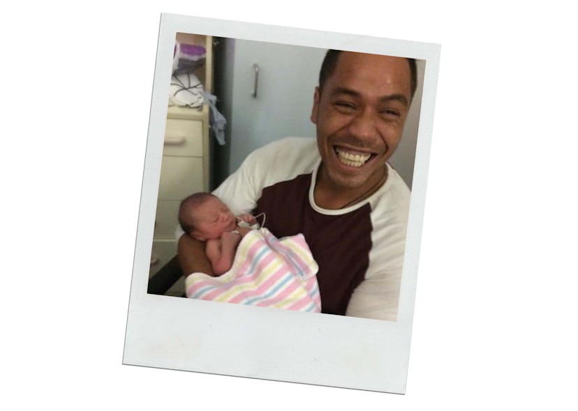Smiling dad holds his newborn baby.