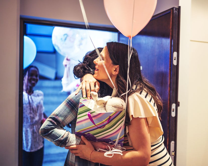 Friends visiting a new mom, bringing gifts and balloons