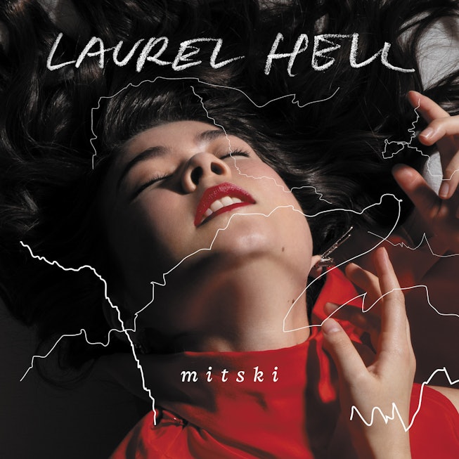 Cover of the album Laurel Hell by singer Mitski where she is lying down wearing a red shirt eyes clo...