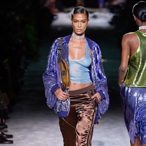 Joan Smalls wearing silk cargo pants, sheer tank top, sequin bomber jacket and stiletto heels