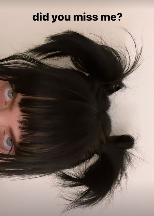Billie Eilish has jet black hair that she styled in Y2K-approved space buns with shaggy bangs.
