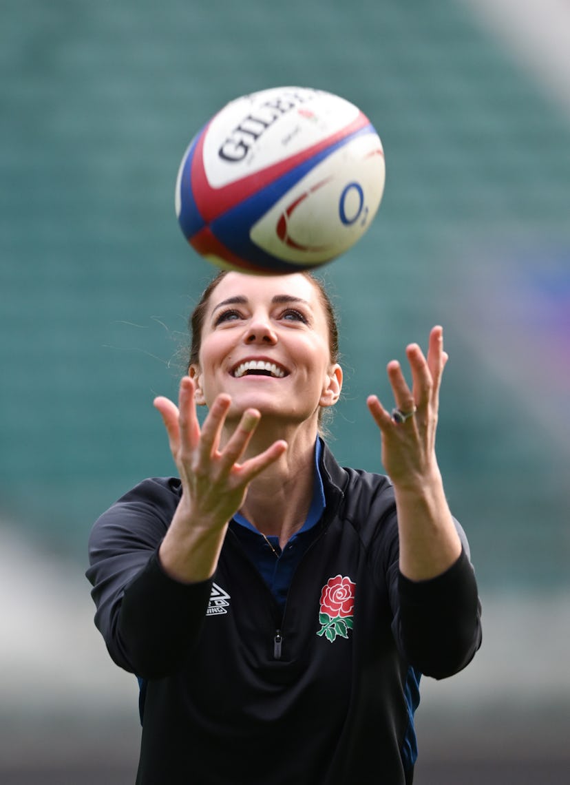 Kate Middleton getting ready to catch a rugby ball 