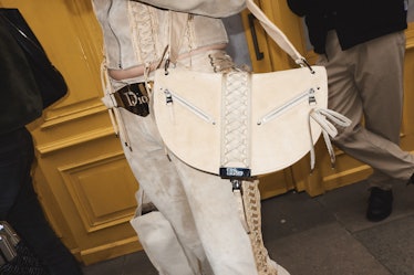 A person carrying a white handbag at London Fashion Week