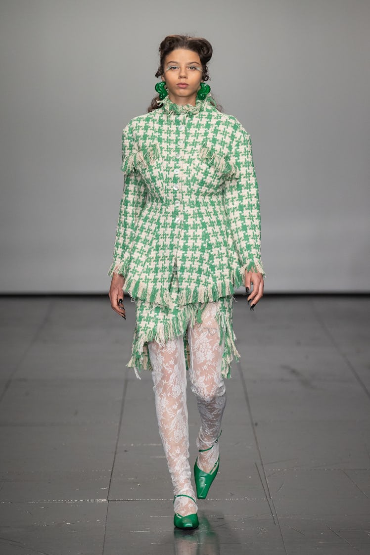 A model in a green-white tweed jacket and skirt by Yuhan Wang at the London Fashion Week Fall 2022