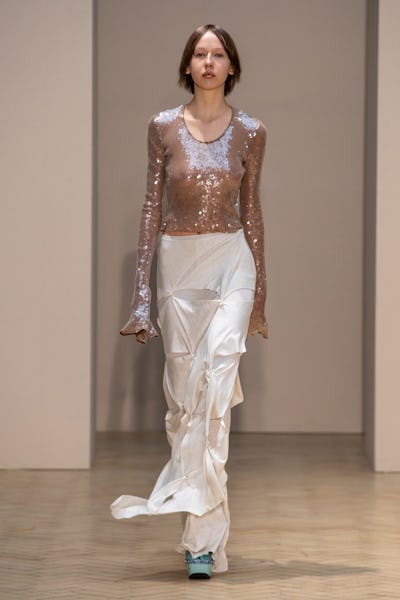 a model wearing a sequin long sleeve top and cream silk maxi skirt on the 16Arlington runway