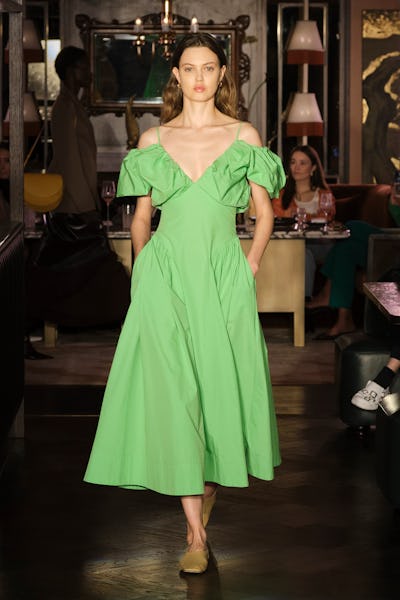 a model wearing a bright green midi dress on the Rejina Pyo runway