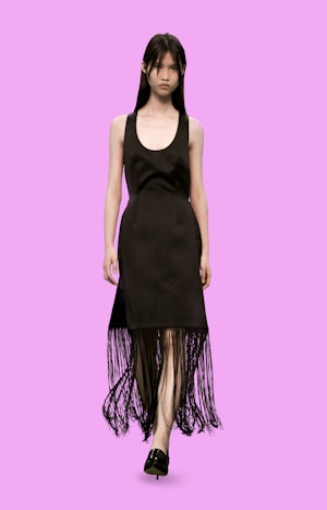 a model wearing a black fringe dress on the Christopher Kane runway