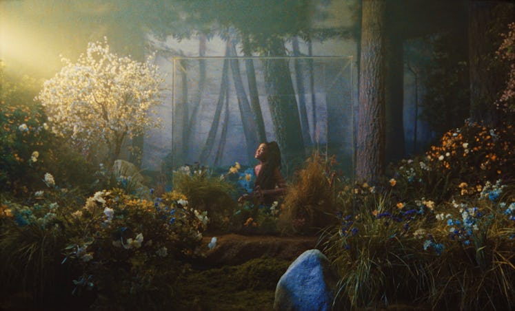 Amber Mark lying down in a field full of flowers in the music video for Bliss