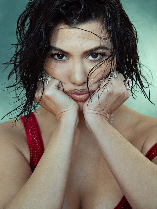 Kourtney squishing her cheeks with her hands, starting from her chin