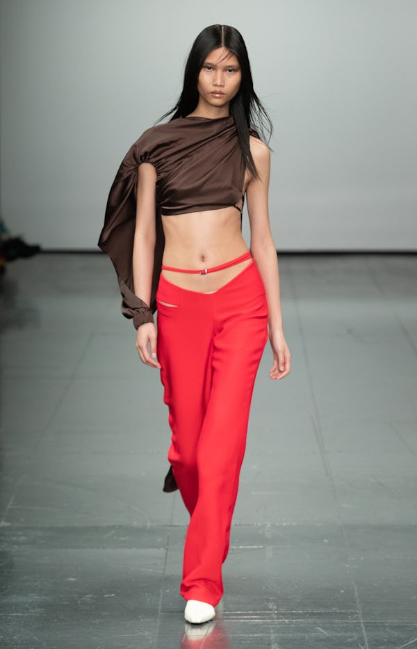 a model wearing a brown silk asymmetric top and low-slung red pants on the Supriya Lele runway