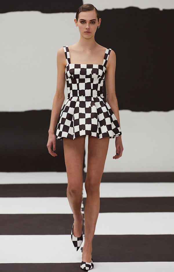 a model wearing a checkerboard print mini dress on the Emilia Wickstead runway