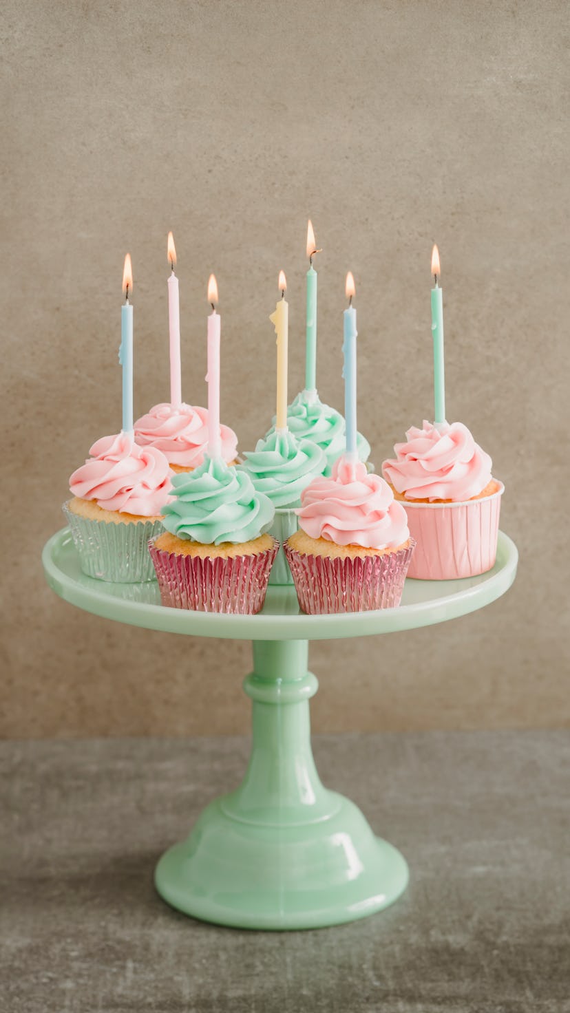 colorful birthday cupcakes on a green milk glass cake stand