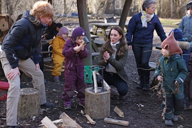 Kate Middleton teaching a child how to chop wood