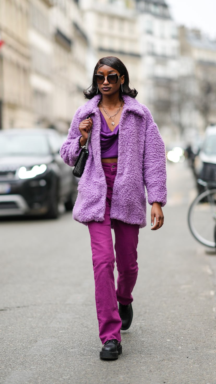 Woman wears a purple outfit.