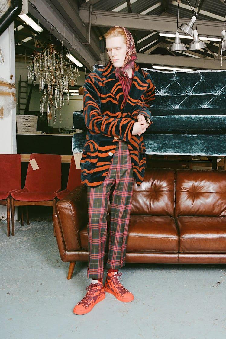 A model wearing a black-orange coat and red-green checked pants by Vivienne Westwood
