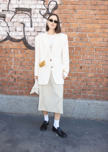 A person wearing a white blazer and long skirt at Milan Fashion Week