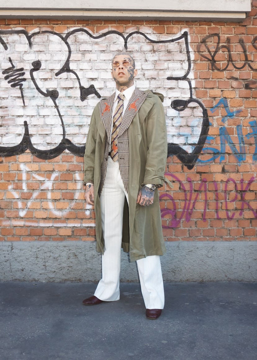 A person wearing sunglasses and a trench coat at Milan Fashion Week