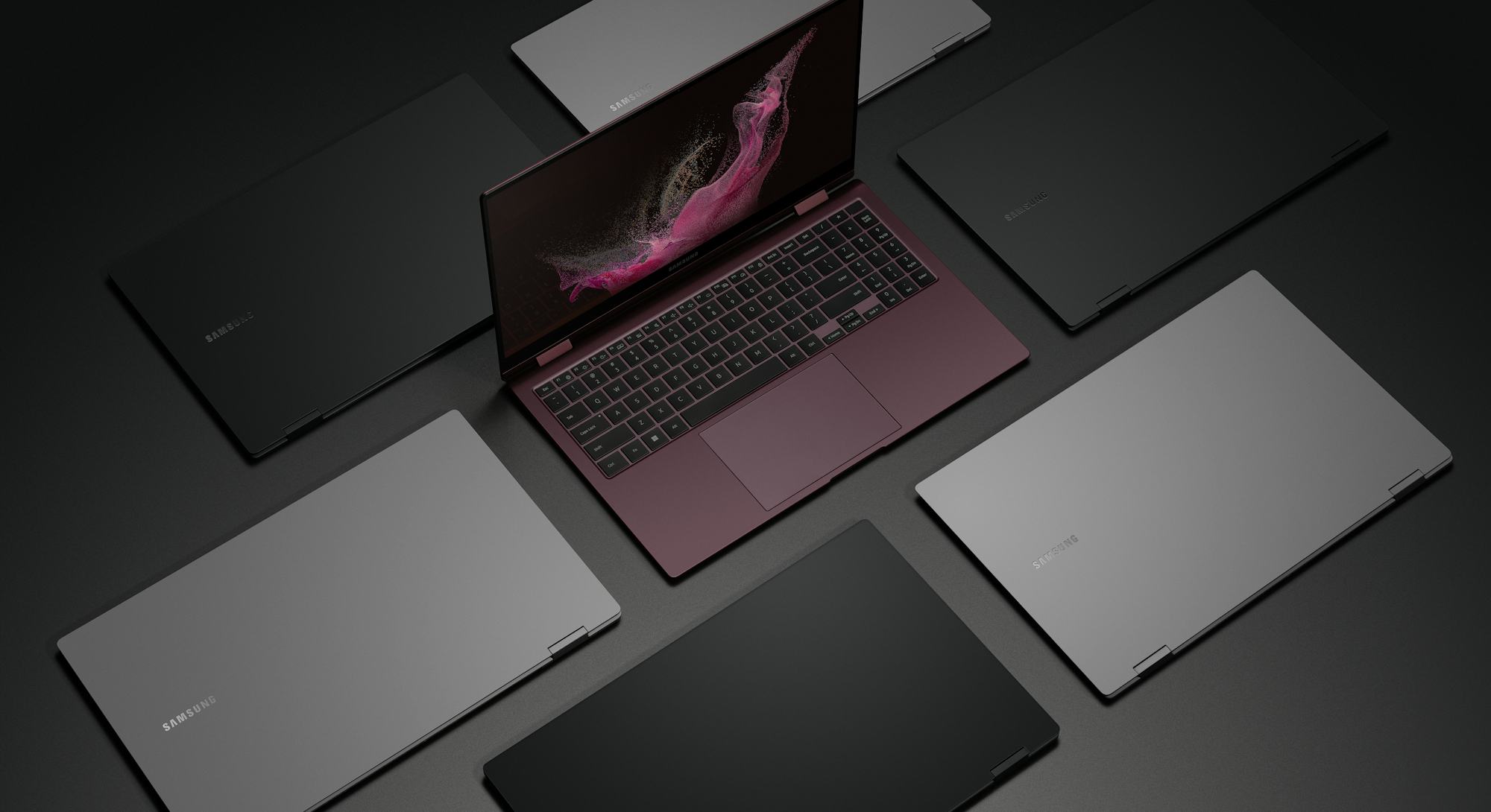 The Galaxy Book 2 Pro 360 in burgundy sitting open surrounded by closed Galaxy Books