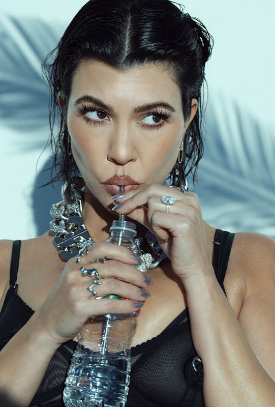 Kourtney drinking water from a bottle with a straw and looking to the side 