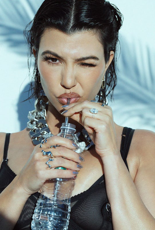 Kourtney winking and drinking water from a bottle with a straw 
