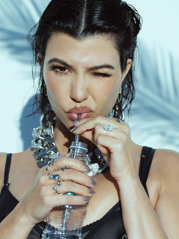Kourtney winking and drinking water from a bottle with a straw