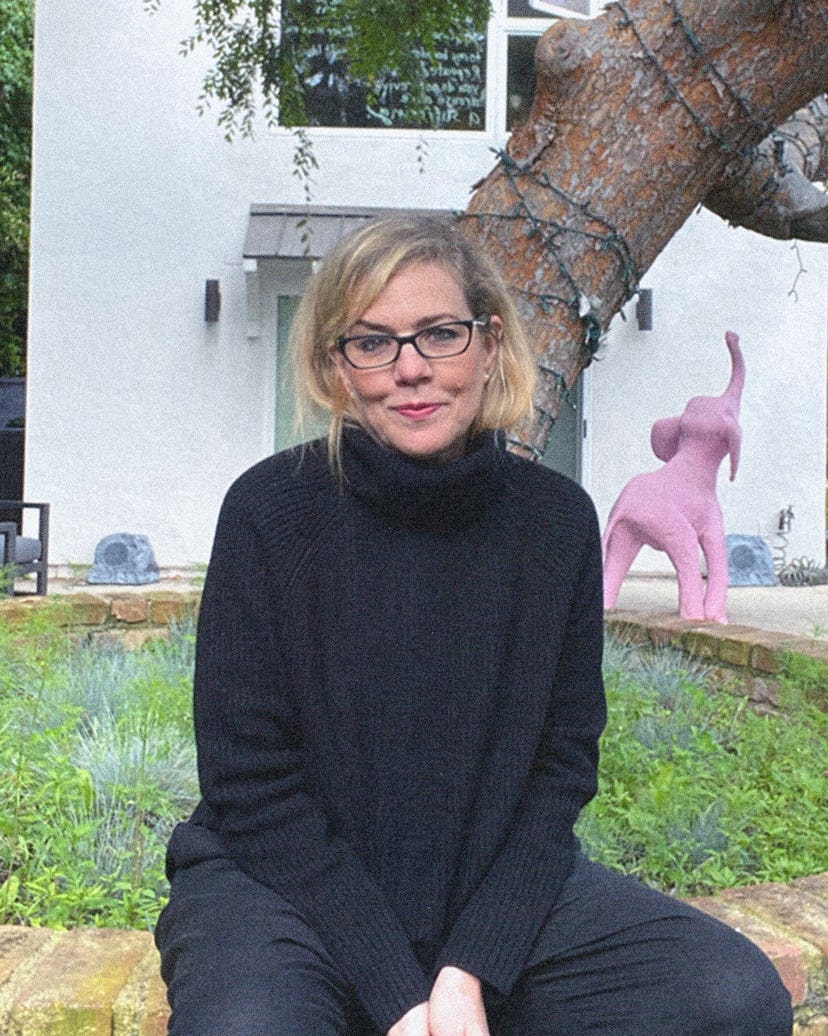 Debbie Millman posing in a black sweater and pants