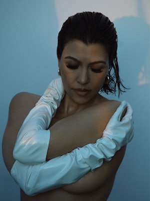 Kourtney Kardashian wearing only Angharad earrings and Wing & Weft gloves, looking down 